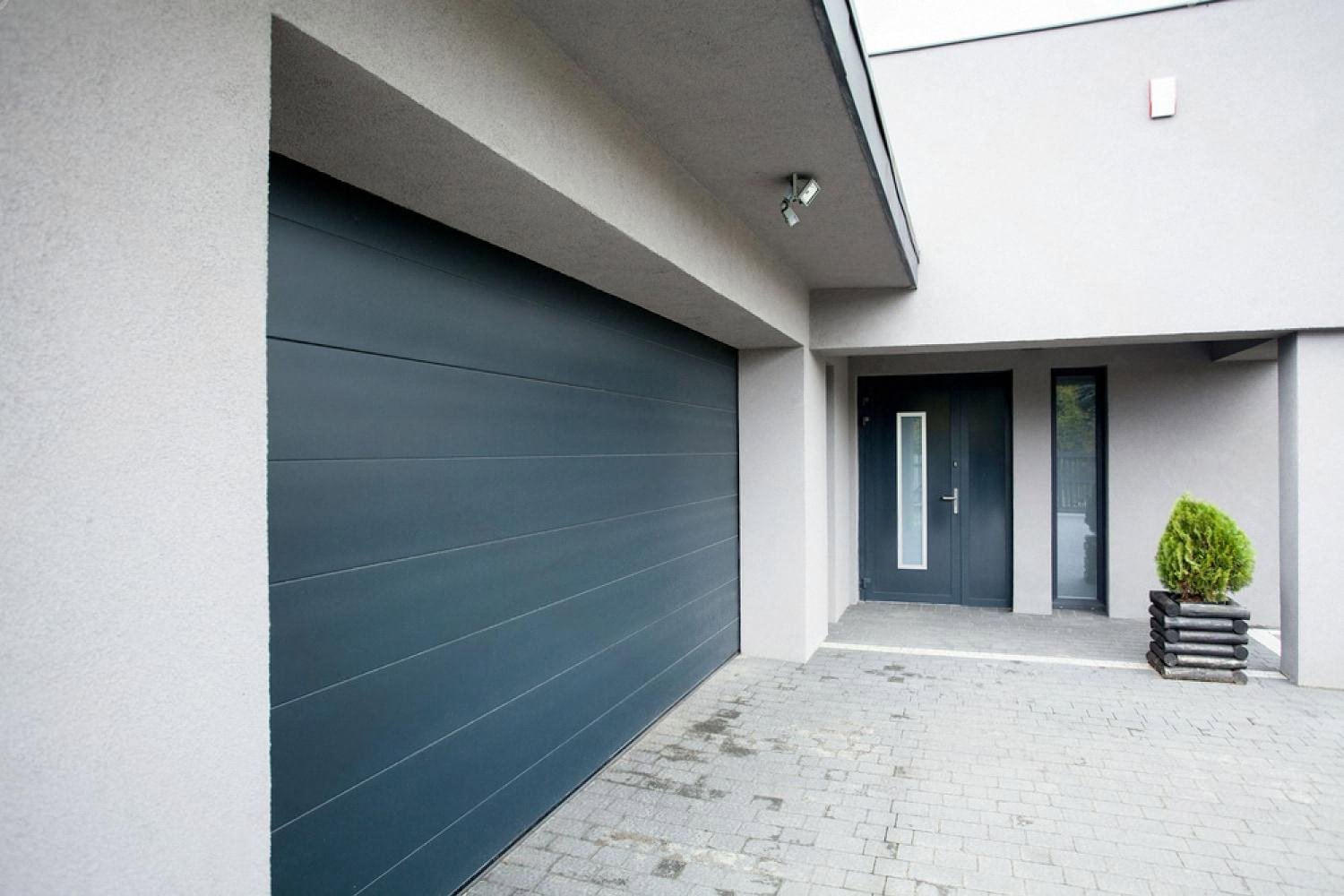 Modern villa garage door and side entrance on a paved driveway